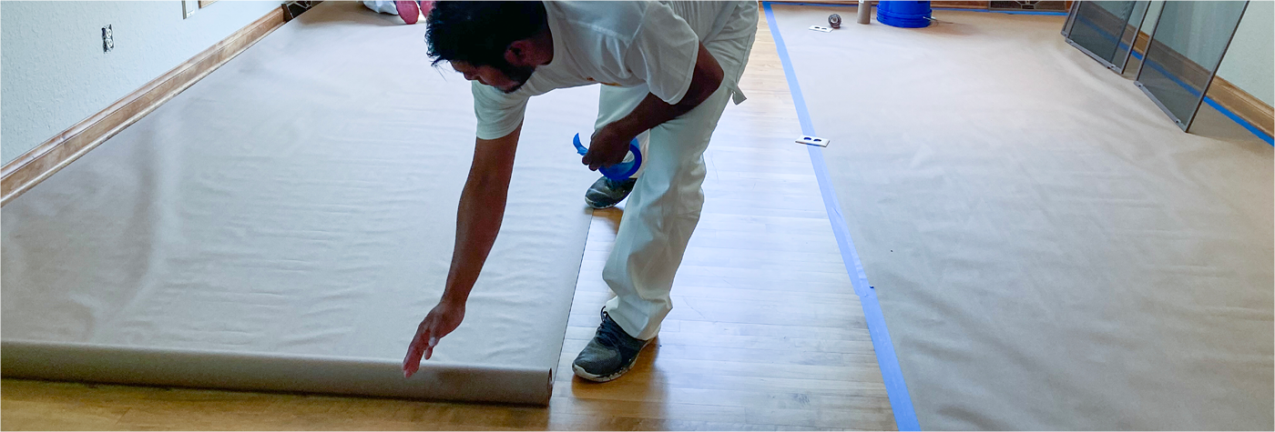 CertaPro Painter prepping floor to work on water damaged wall.