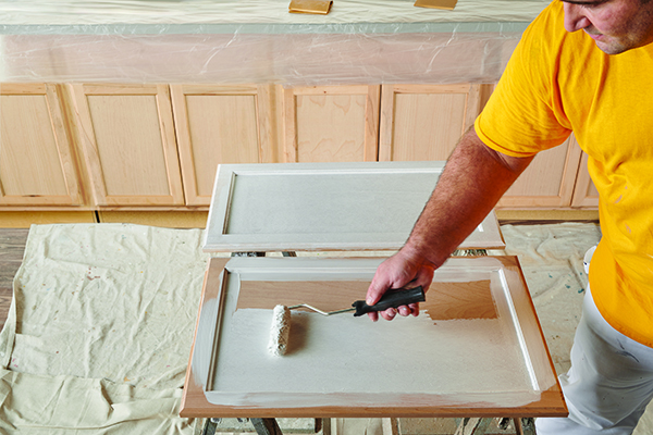 man painting kitchen cabinets