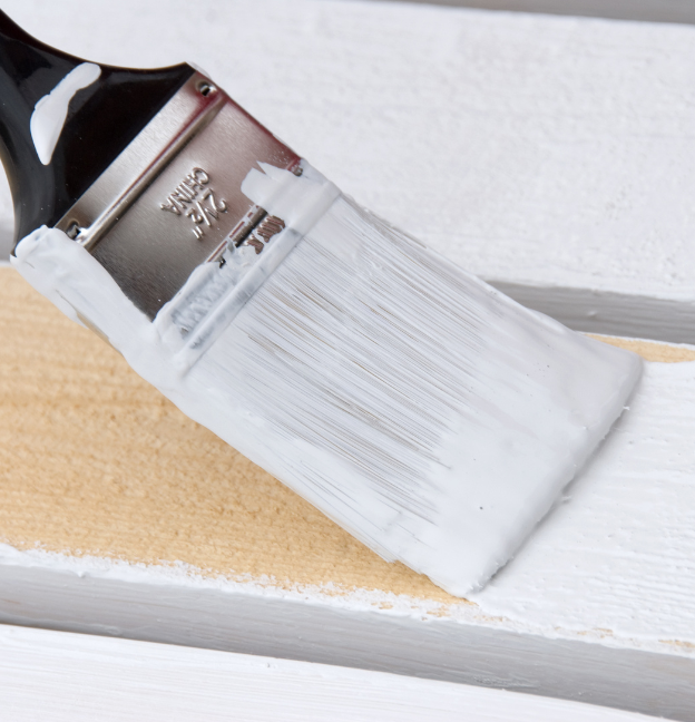 paintbrush painting white paint on wood in historic home