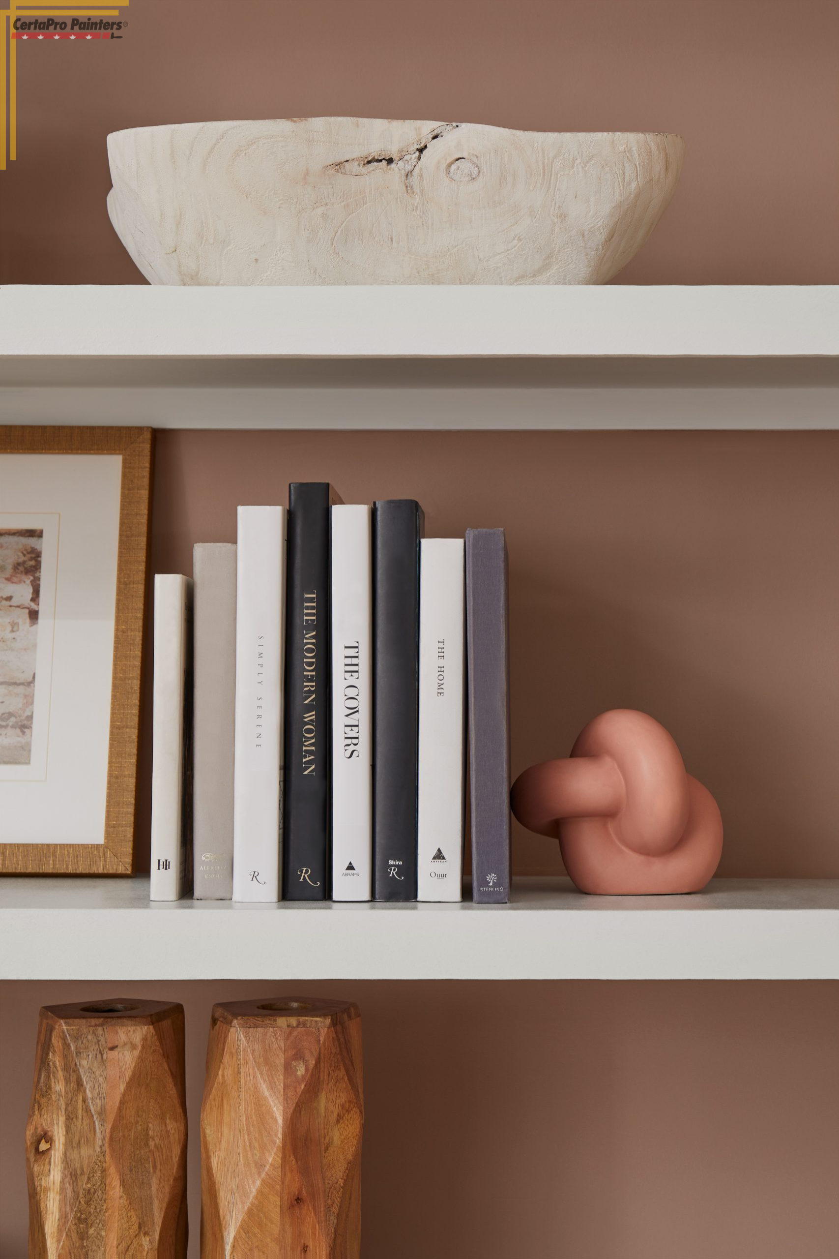 white wall shelves with books and decor on a pink wall
