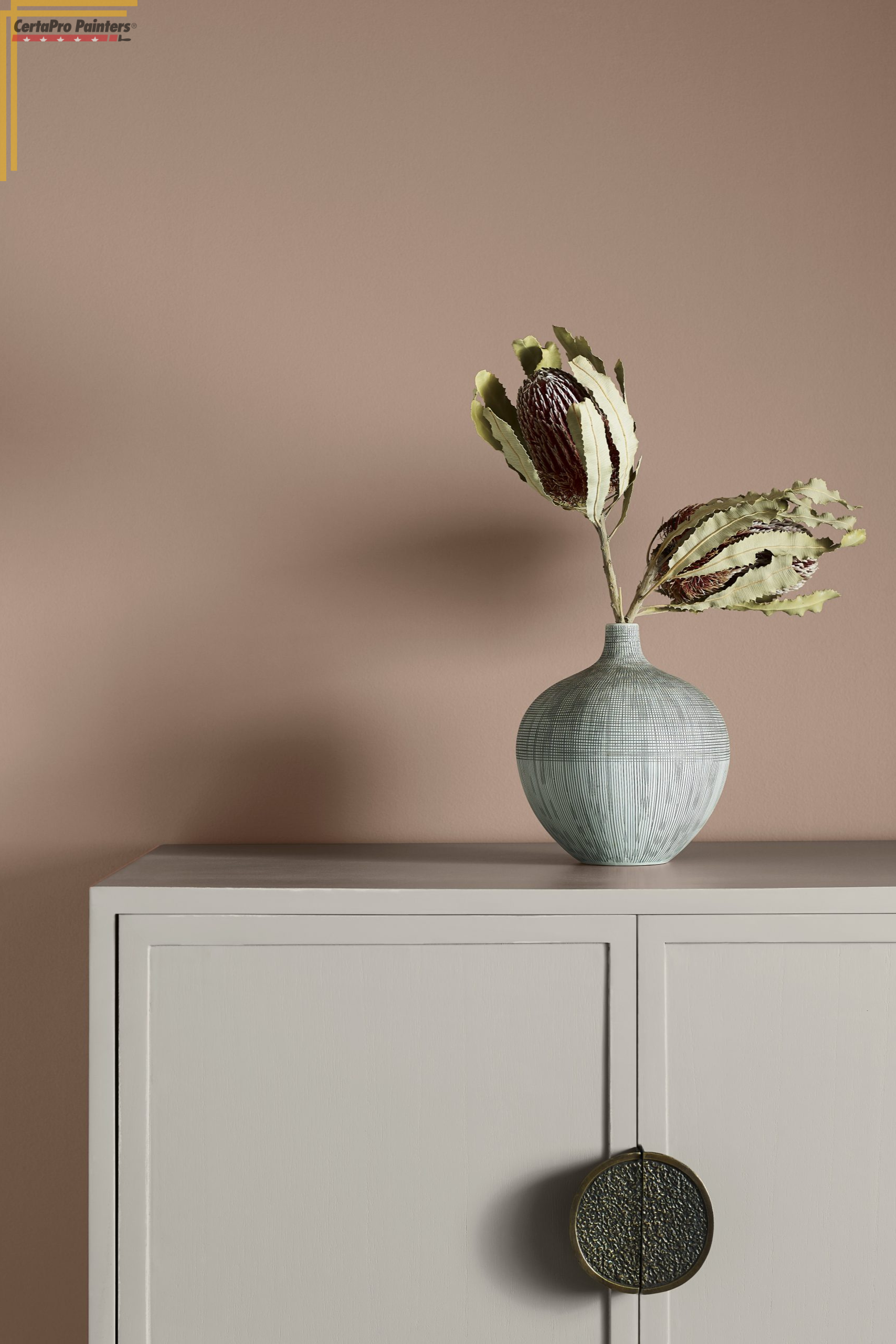cabinet with vase and dried flowers on top