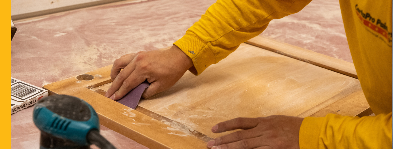 certapro painters team member sanding kitchen cabinets
