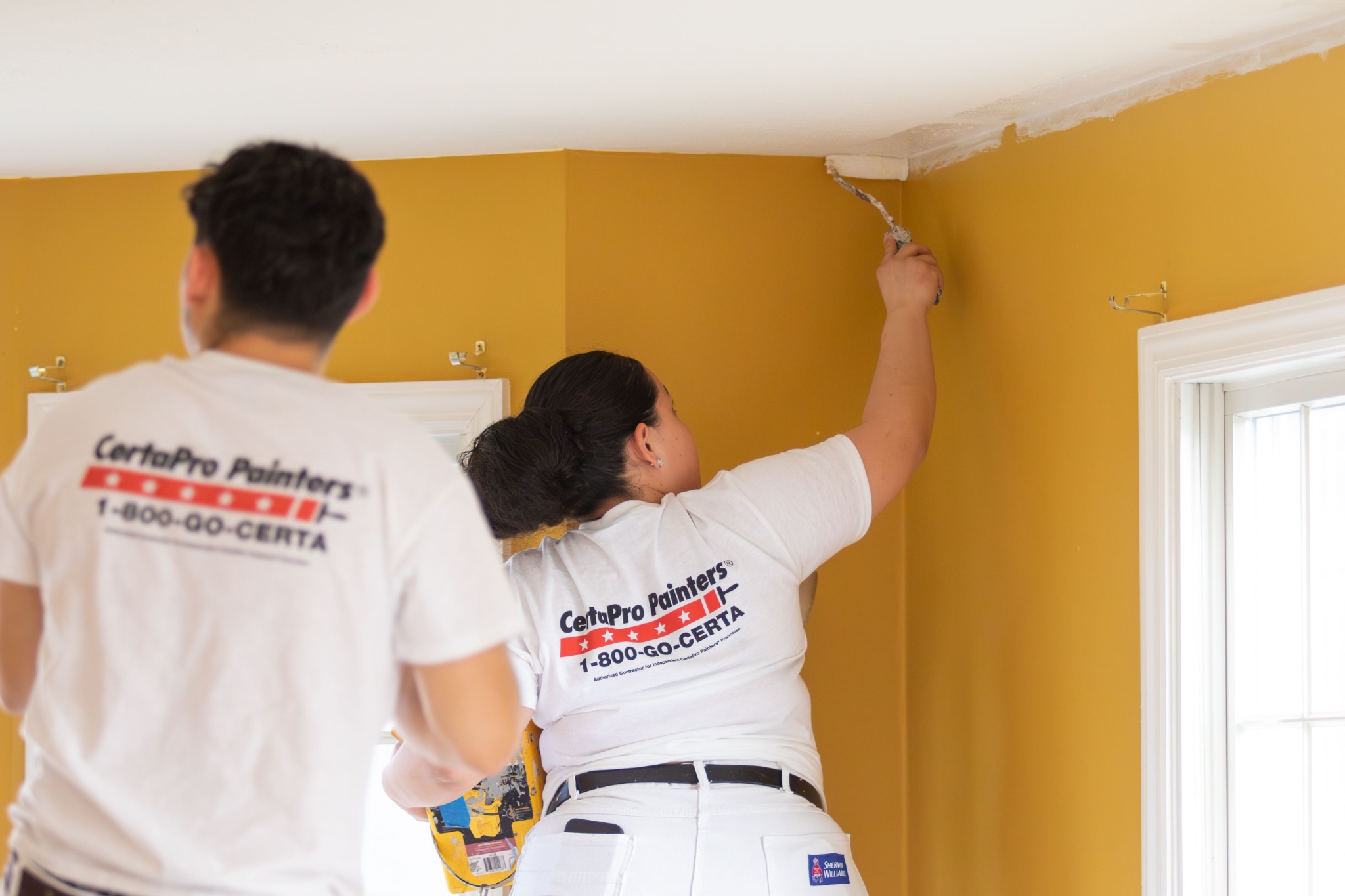 CertaPro Painters painting the upper walls of a residential interior