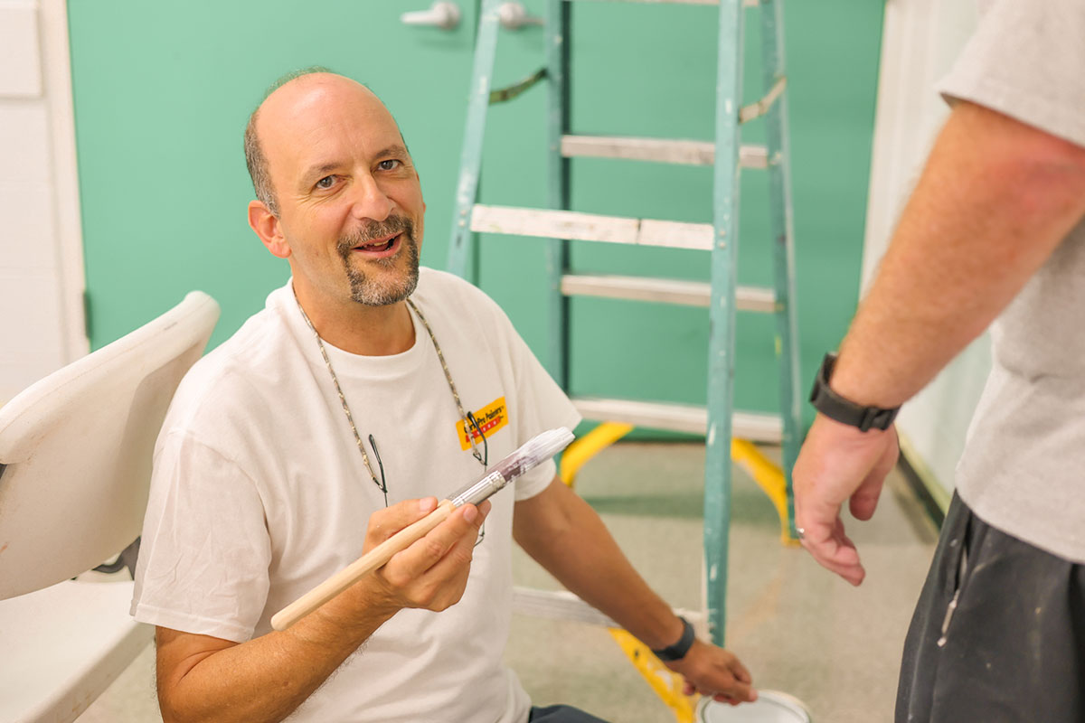 team member painting interior of building