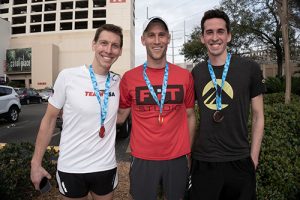 3 team members wearing award badges
