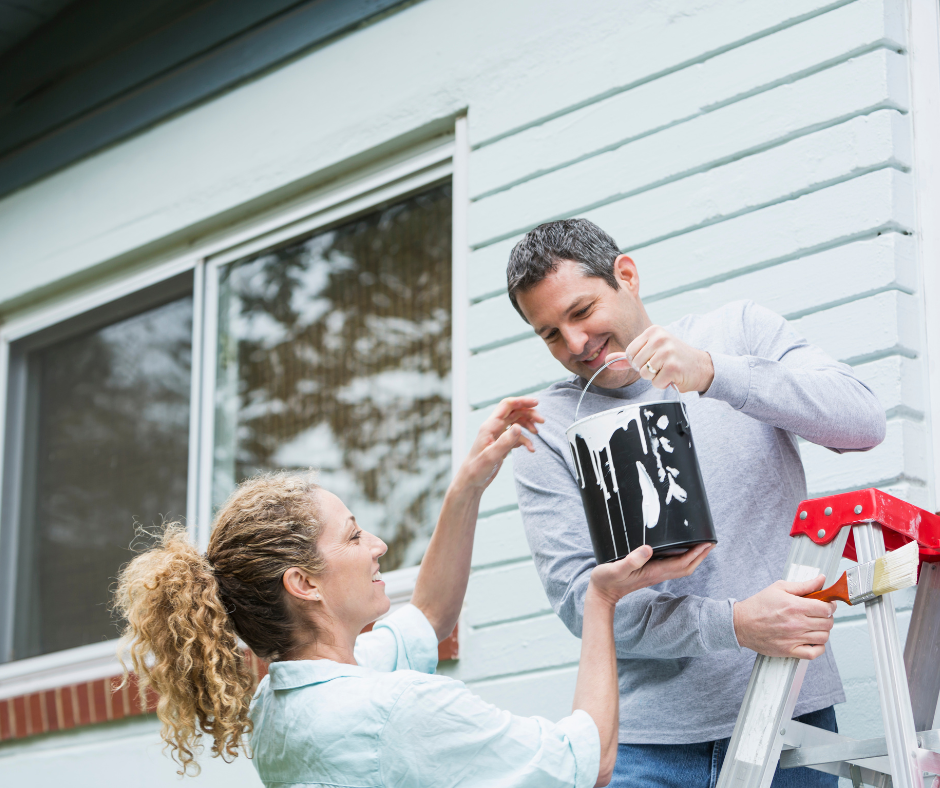 two homeowners painting their home exterior