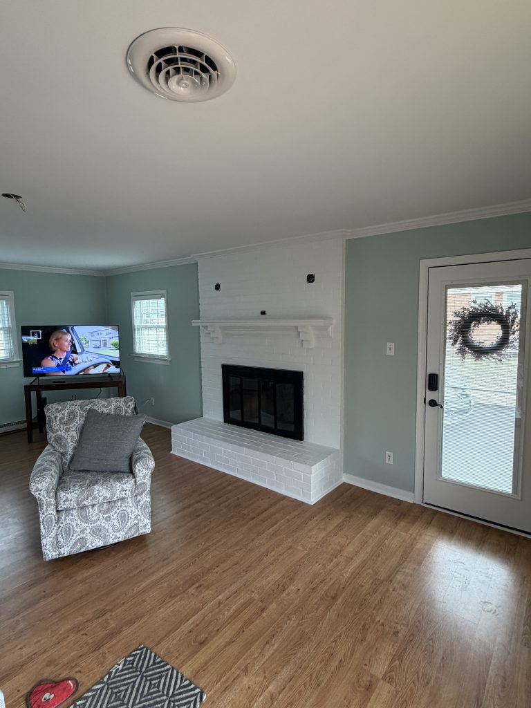 green painted living area with white fireplace
