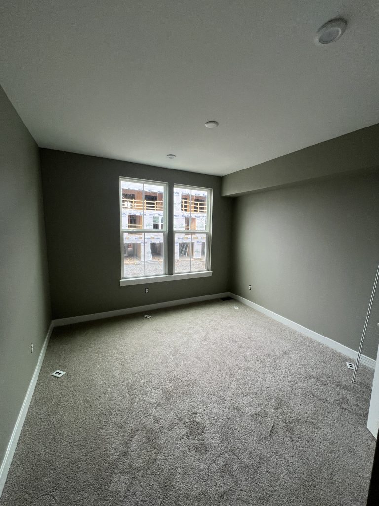 empty bedroom interior with dark grey walls after repaint