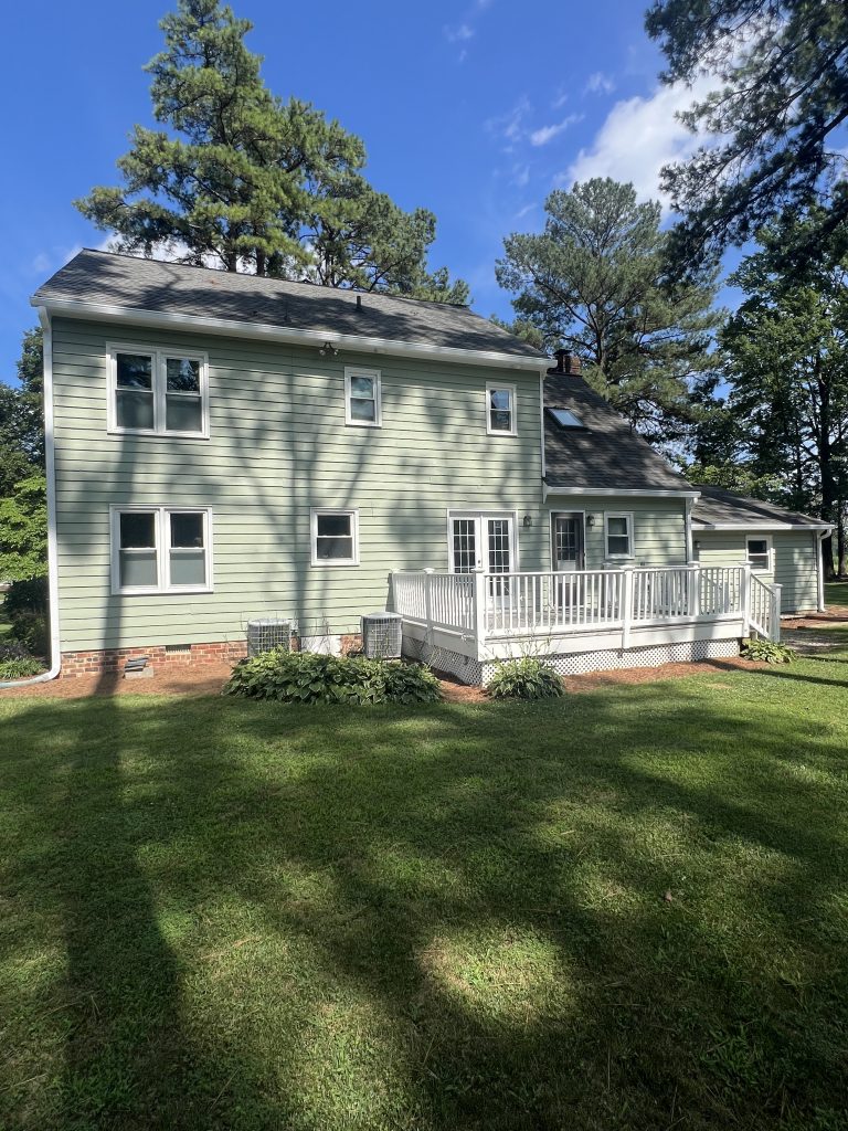 rear side of house with green siding after painting