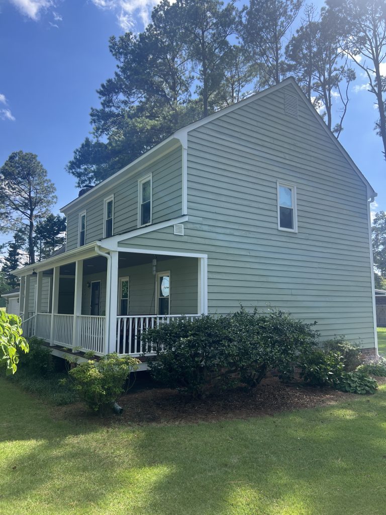 house exterior with light sage green siding after repaint