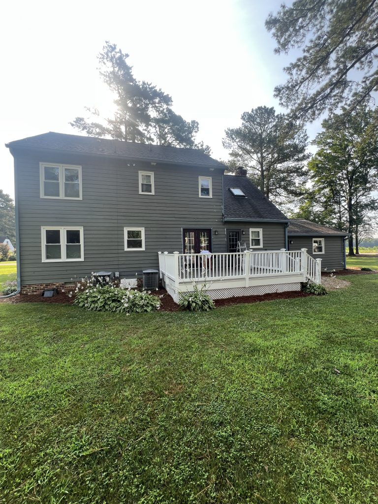 rear side of house with green siding before painting