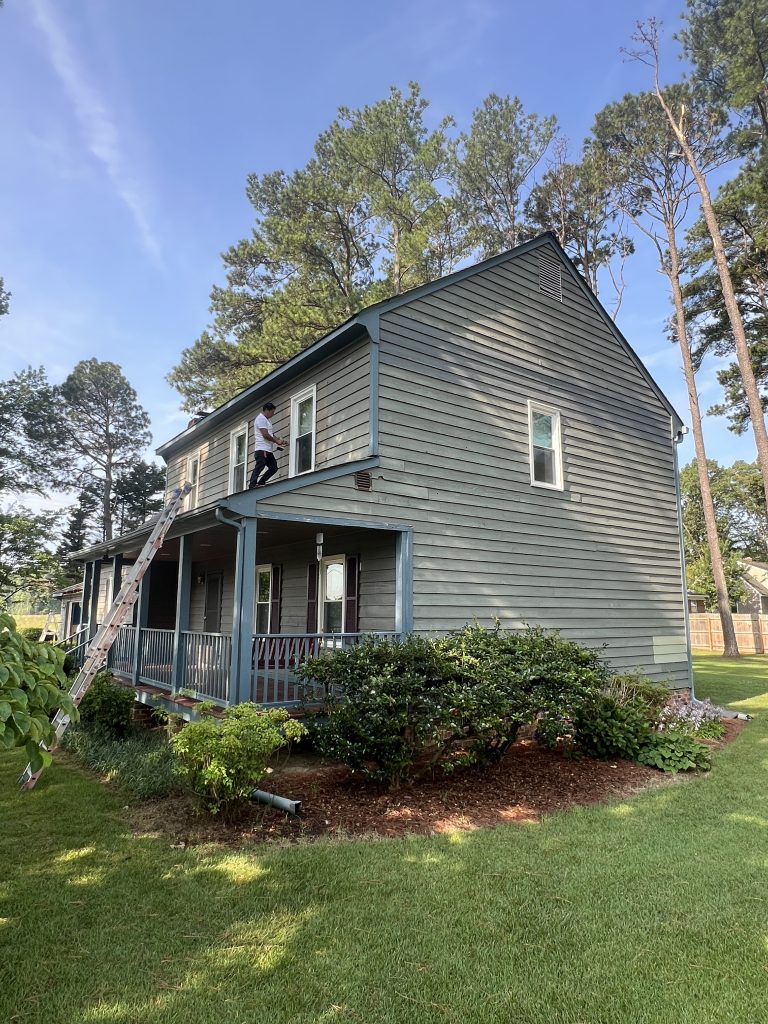 house exterior with dark sage green siding before repaint