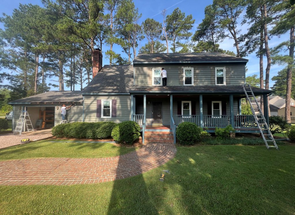 front exterior of house with dark sage green siding before repaint