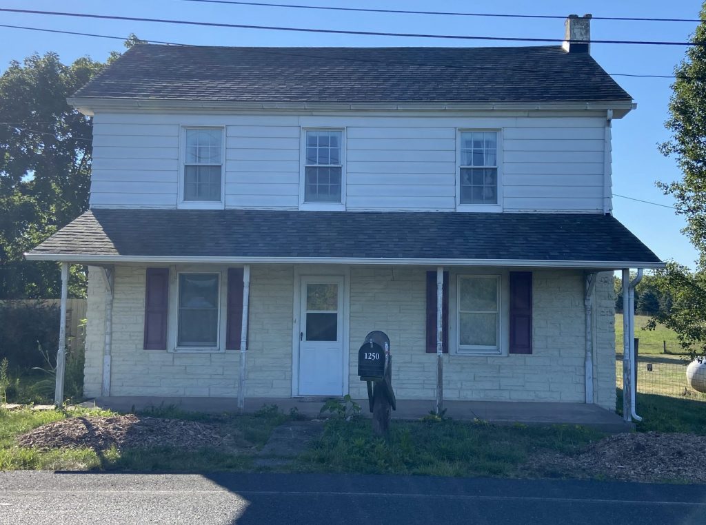 White house with grey roof before power washing and painting