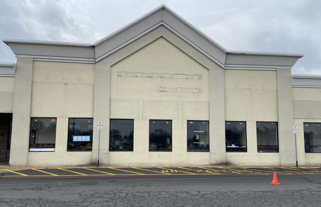 tan cement and stucco building with a lot of wear and tear