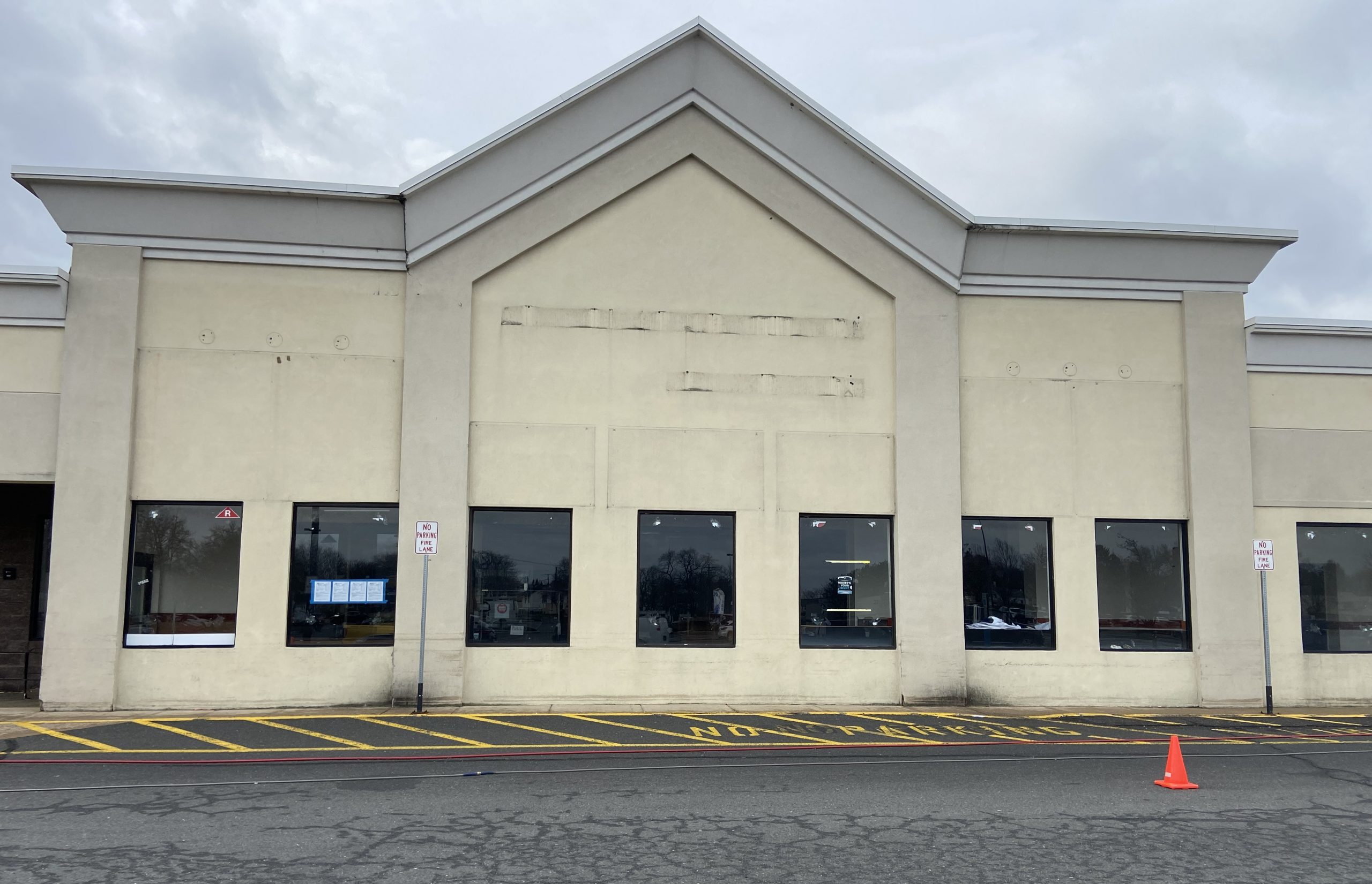 tan cement and stucco building with a lot of wear and tear