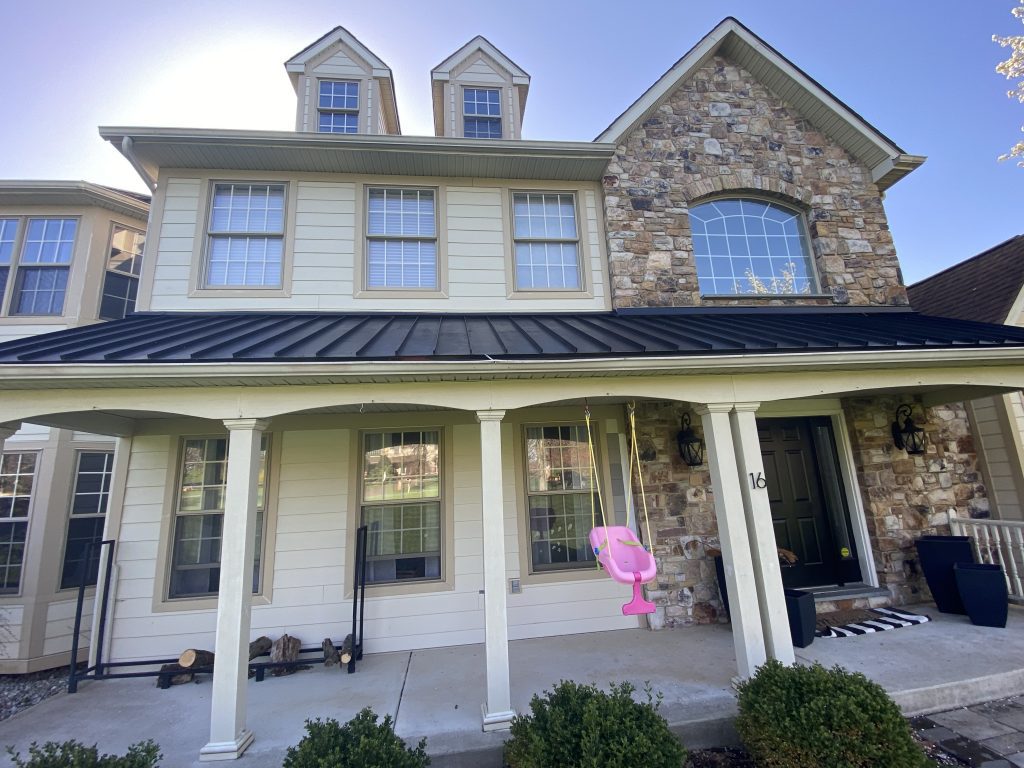 front of tan and stone house before power washing and painting
