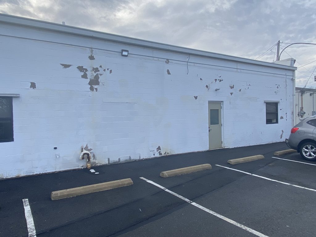 white cement wall with a lot of wear and tear