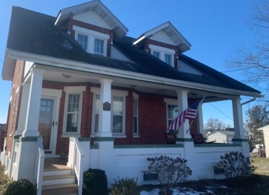 front of brick house with white trim and white front porch