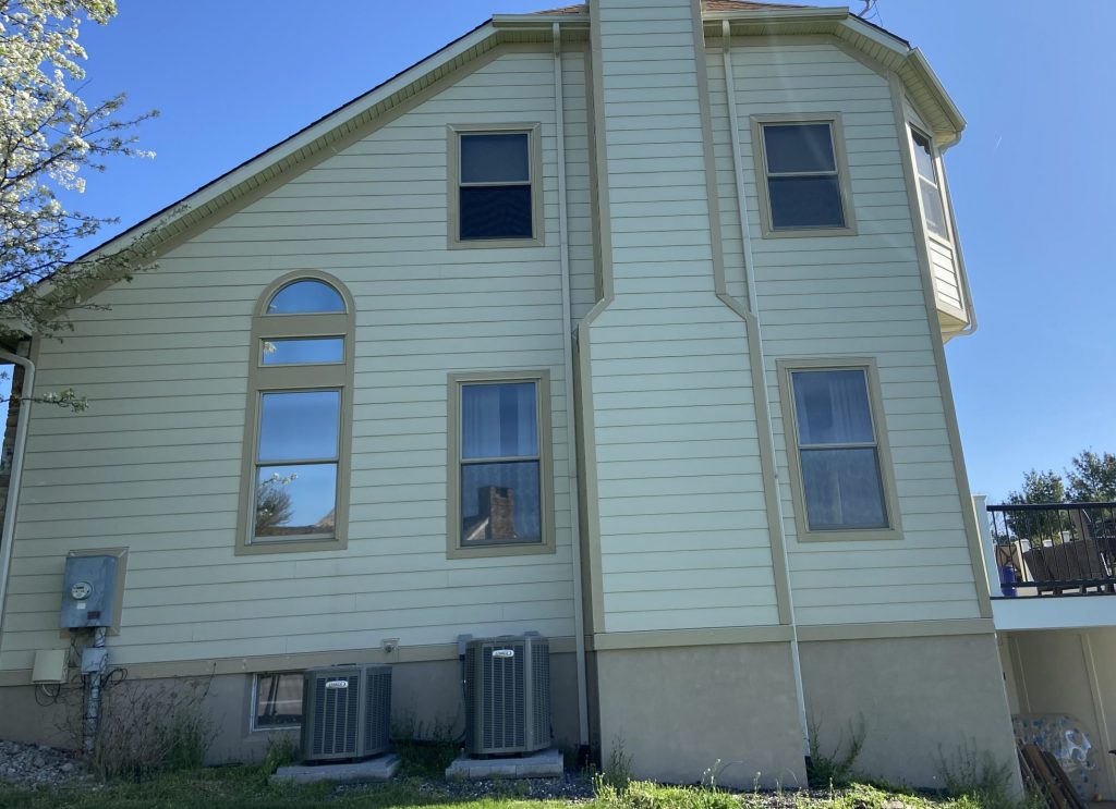 side of tan colored house before power washing and painting