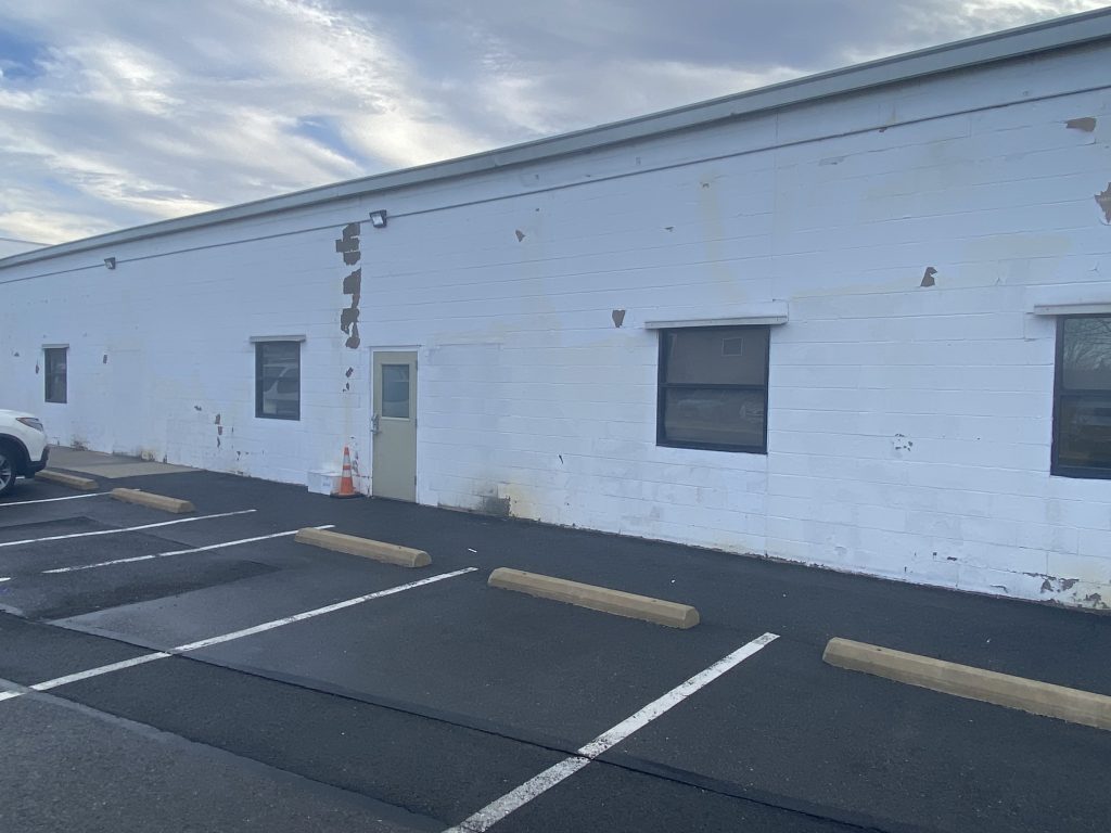 cement wall painted white with a lot of wear and tear