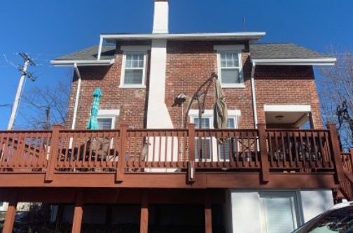 brick house with white chimney and brown deck
