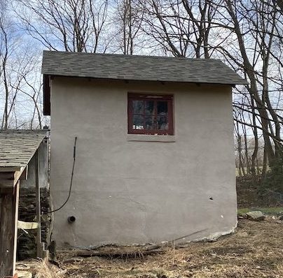 side of tan shed with small window