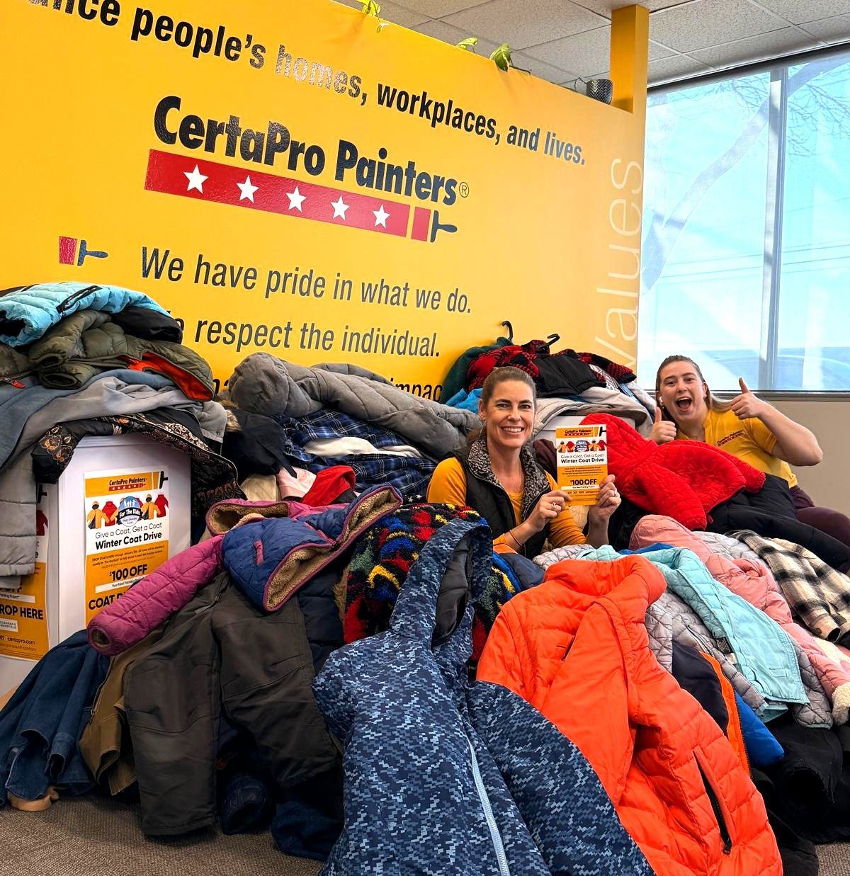 two people in a pile of donated coats
