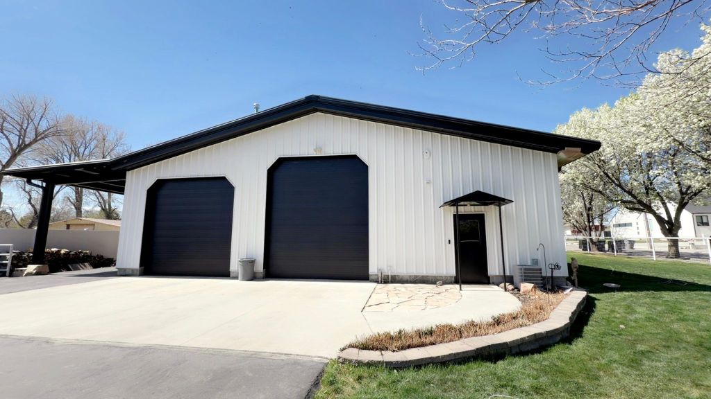 pole barn exterior painted white with black doors and roof