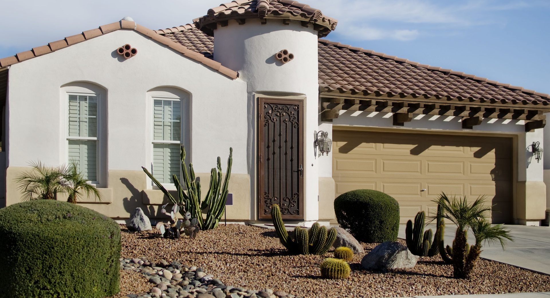 white and brown stucco home with garage