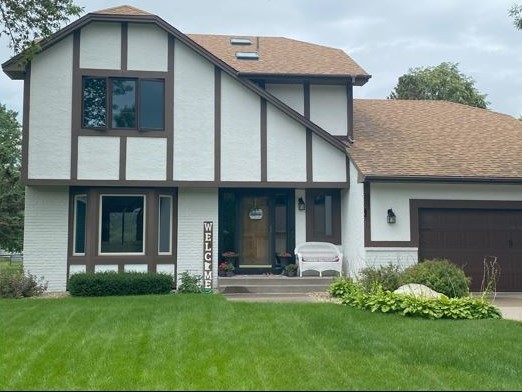 front of house with white stucco and brown trim