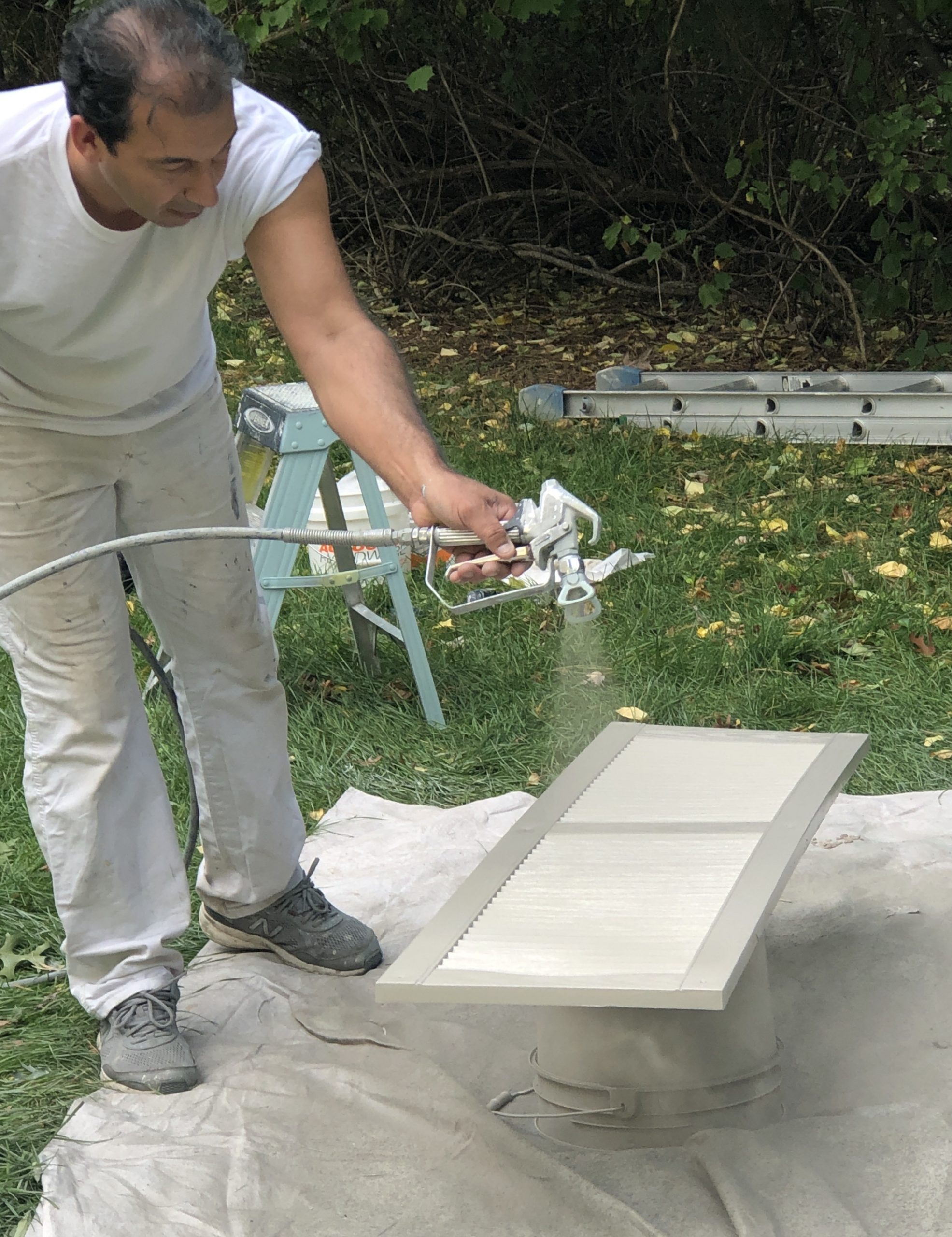 spaying paint on shutters