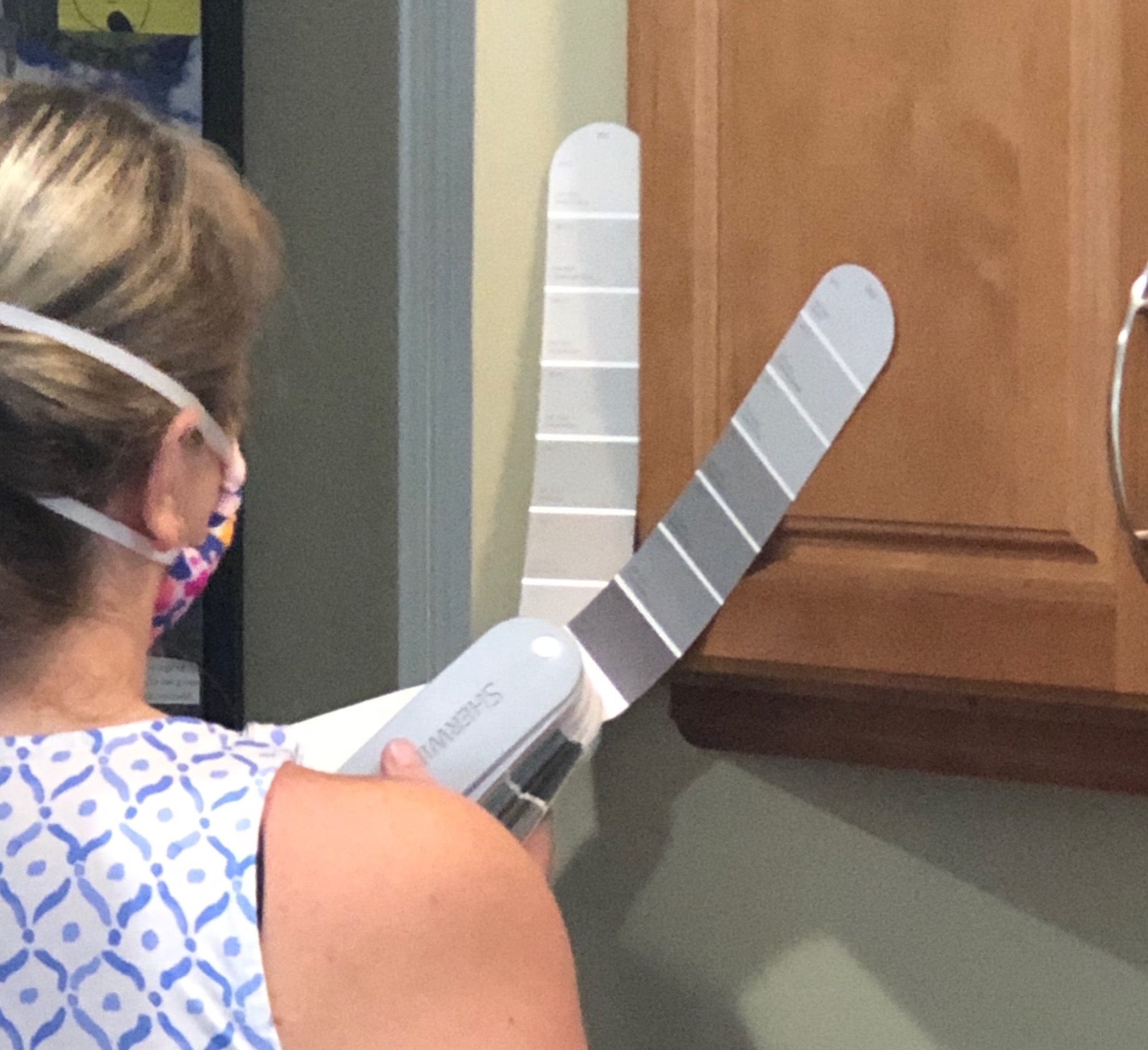 Designer with color fan deck against kitchen cabinet