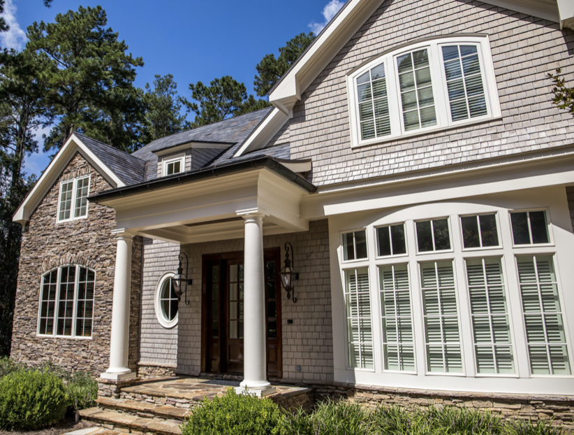 Close up of shingled home with white trim and gray shingles