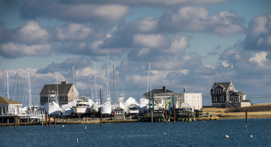 Vacation homes in Scituate MA in background, the Atlantic ocean with boats in the foreground