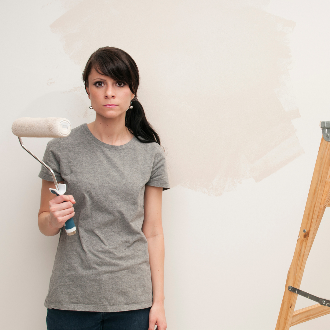 Frustrated homeowner holding a paint roller
