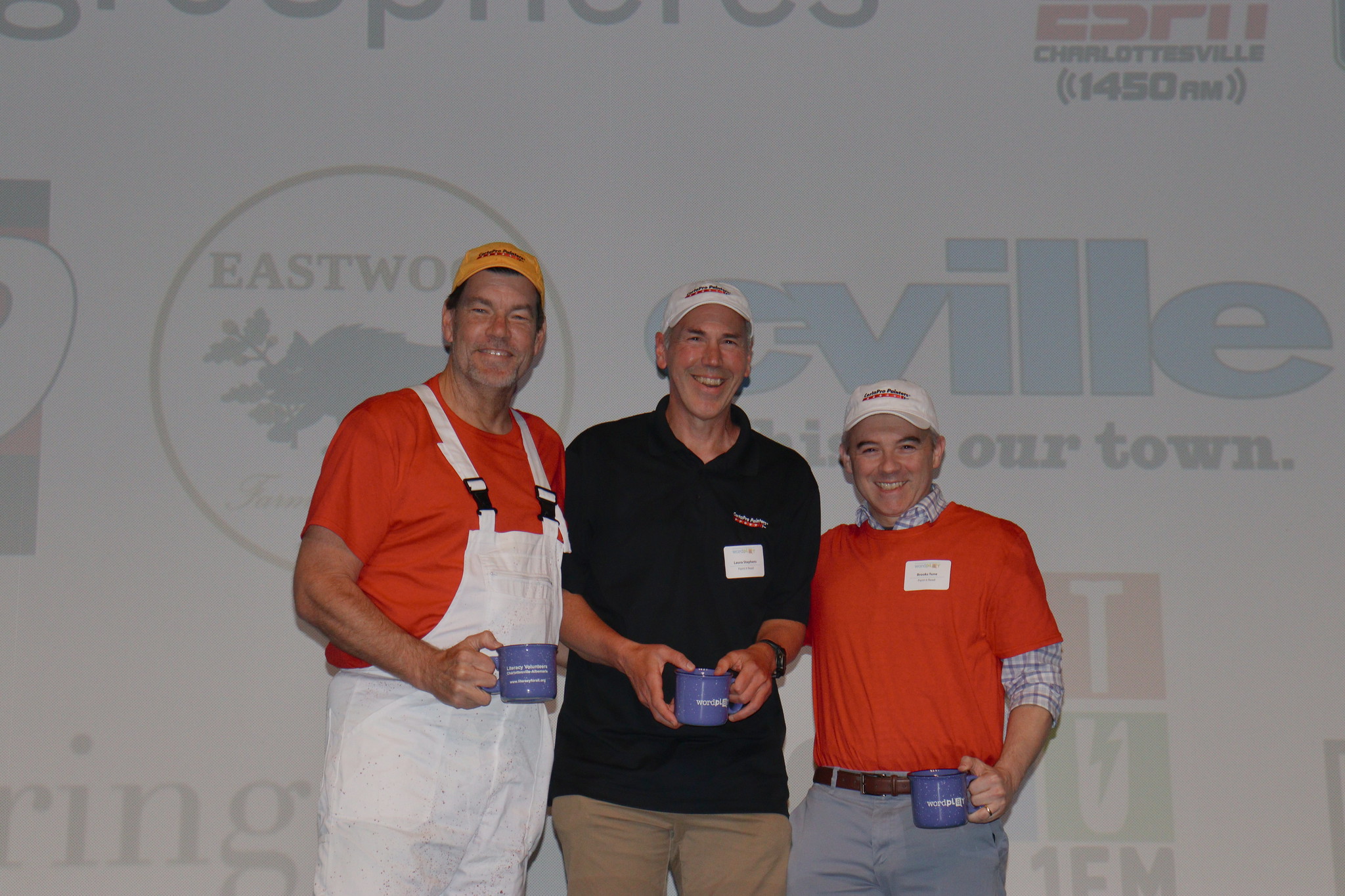 three men standing in front of fundraiser event backdrop