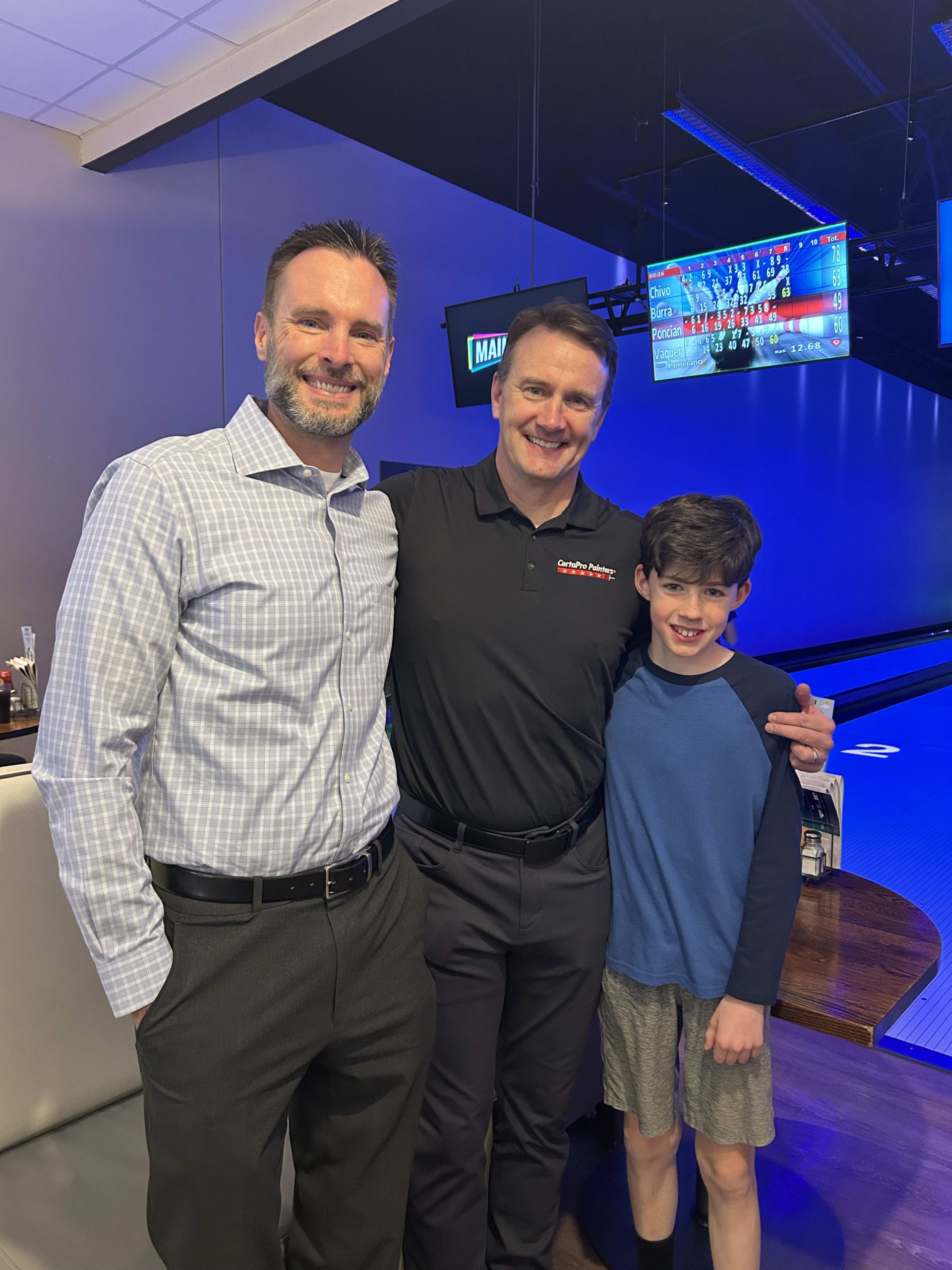 two men and younger boy at bowling lane