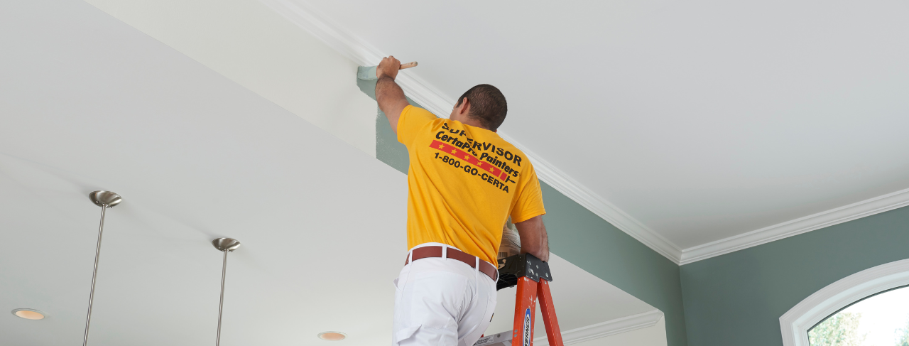 CertaPro Painter interior painting a ceiling from white to green