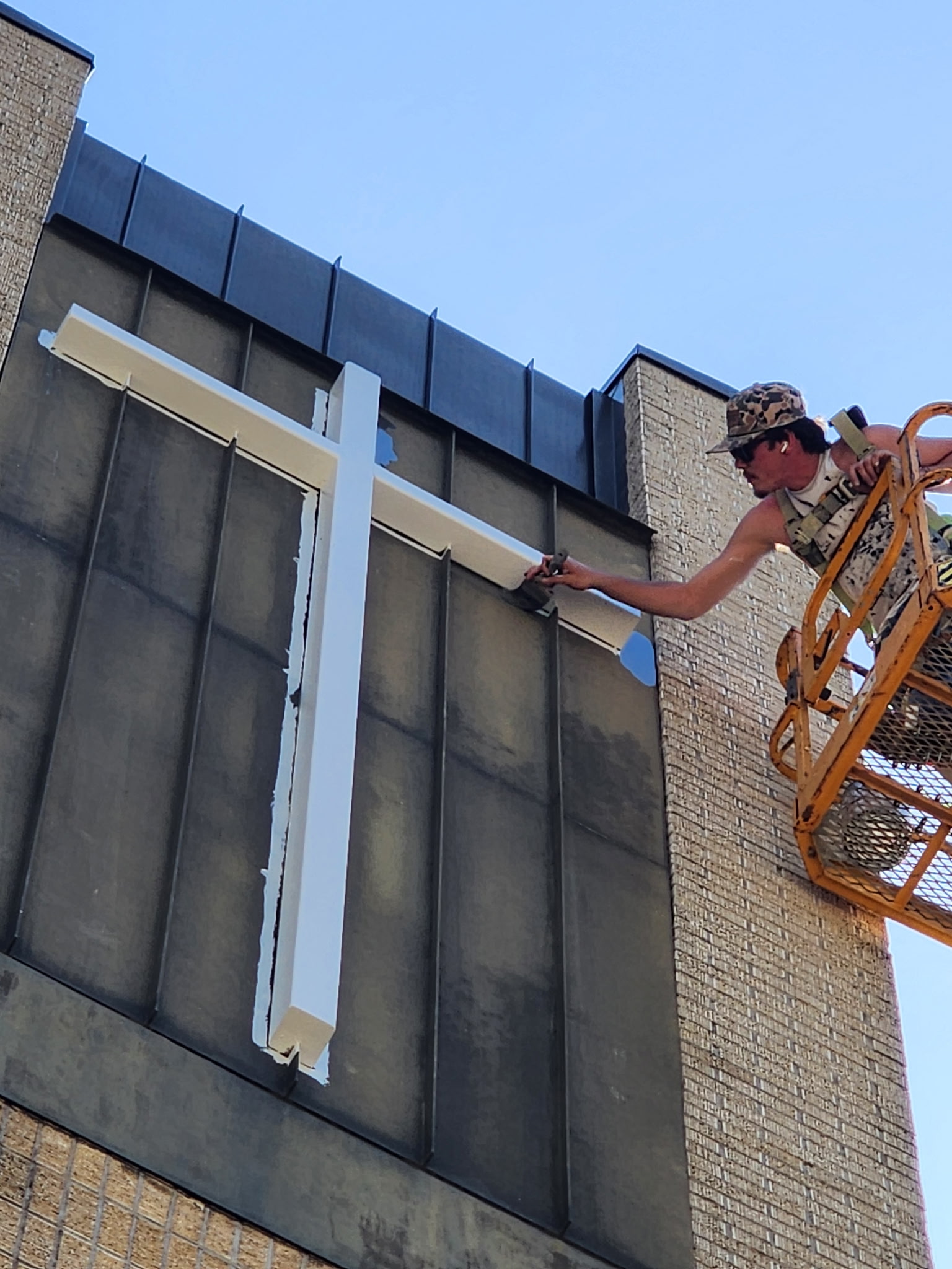 painter on boom lift painting building