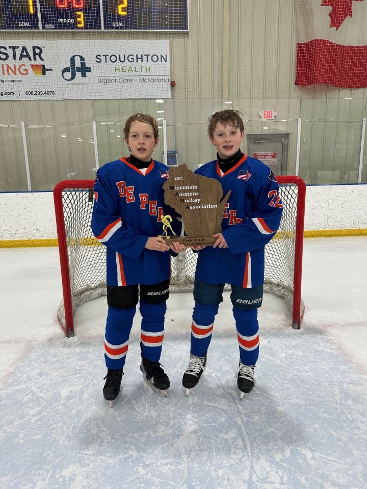 two peewee hockey players holding sign