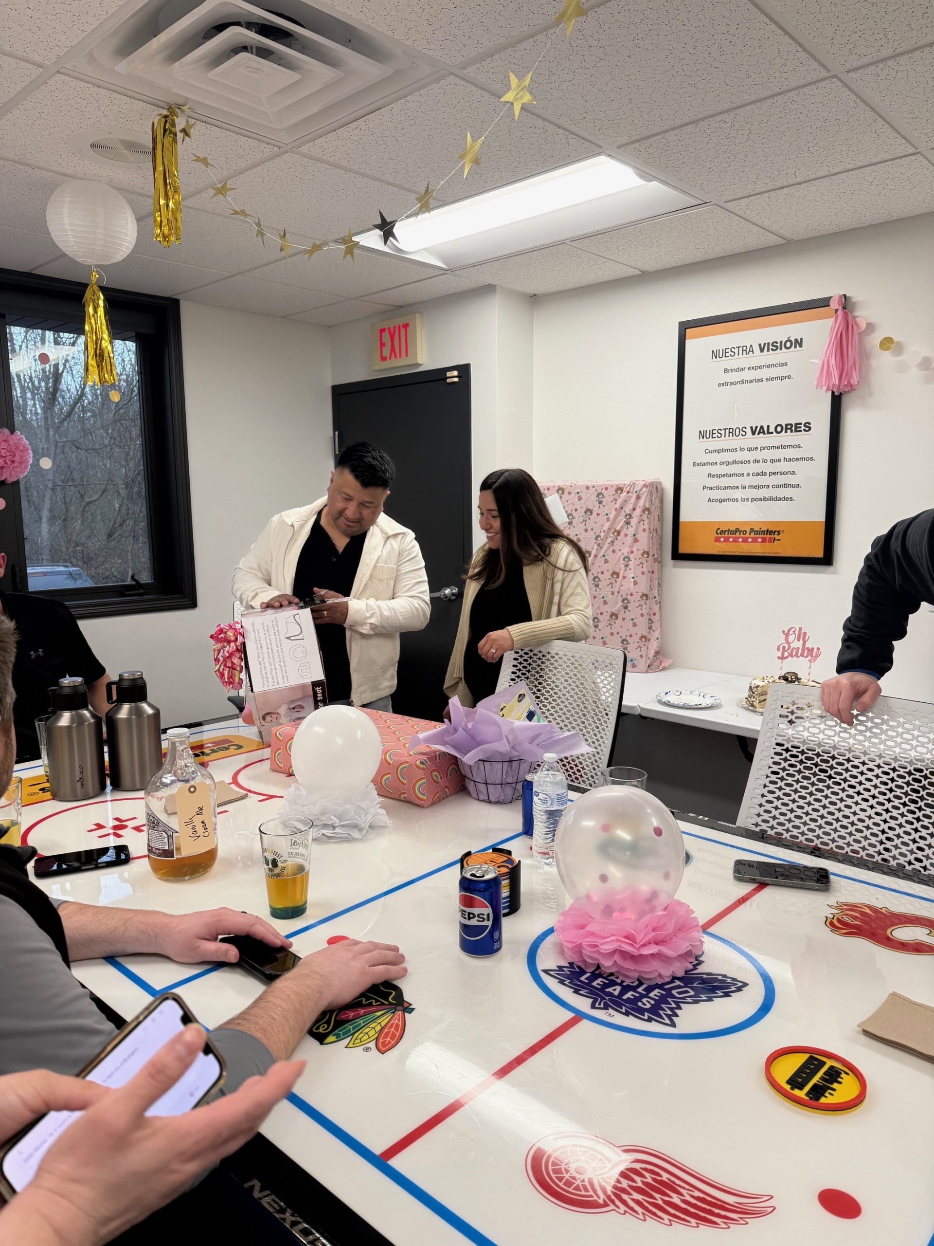 couple opening gifts at baby shower