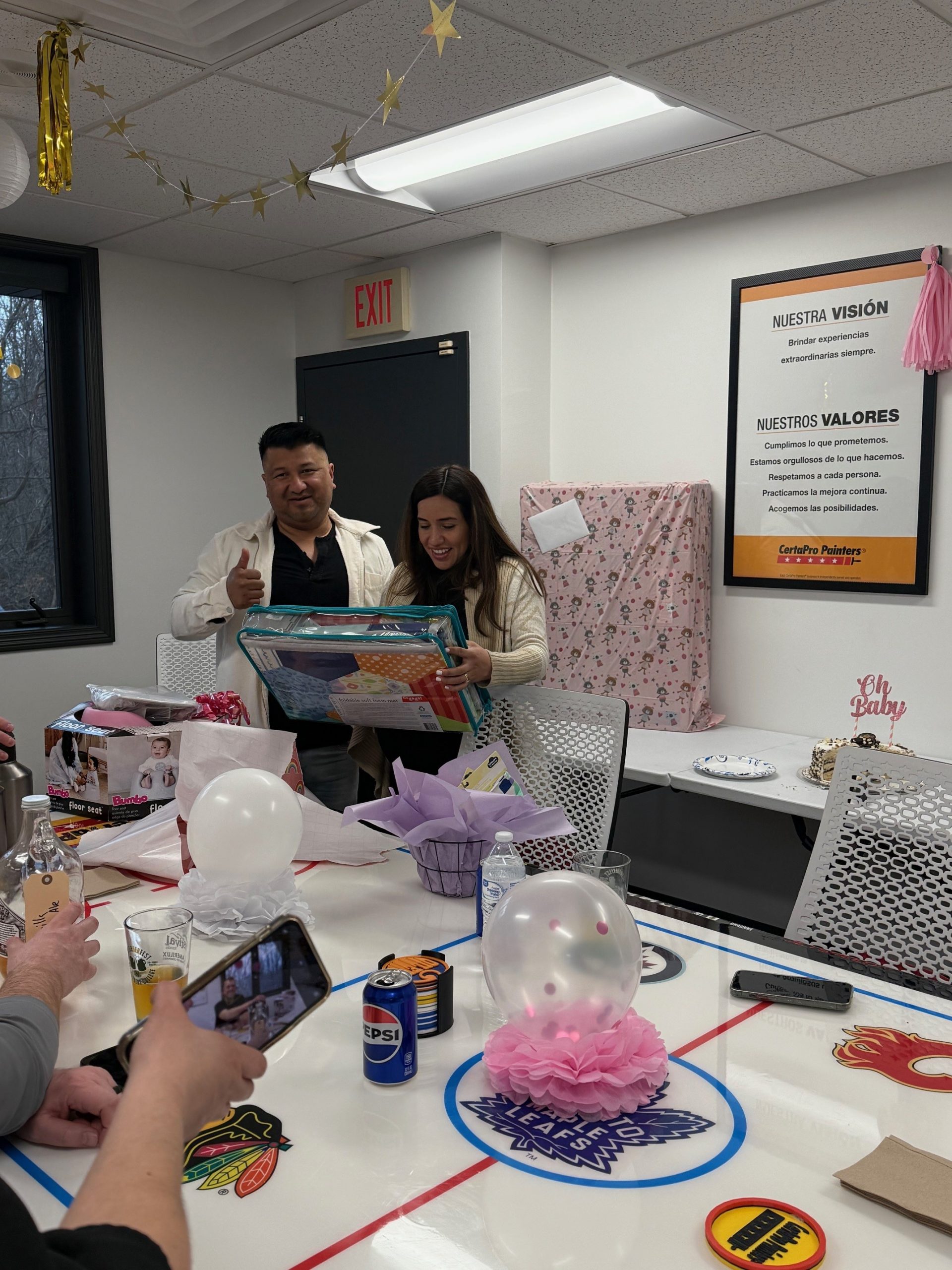 couple opening gifts at baby shower