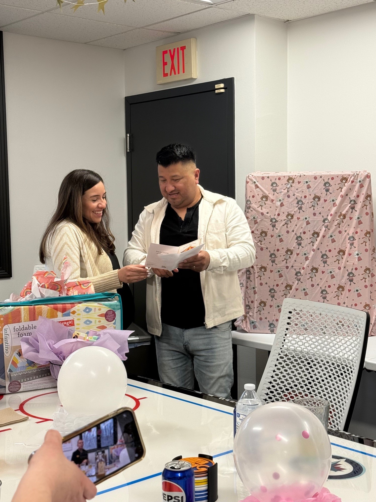 couple opening gifts at baby shower