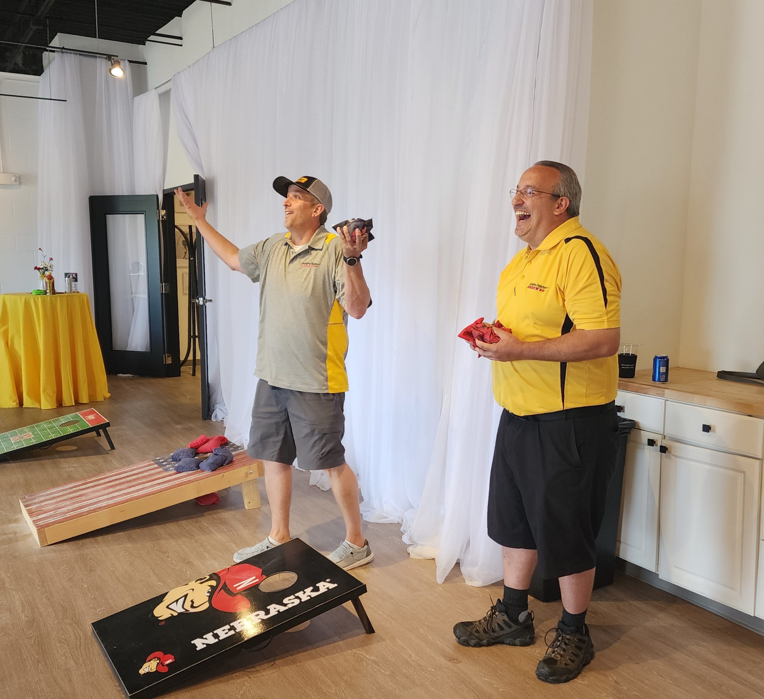 Two men playing corn hole at the PJ Morgan Real Estate BBQ Bags Tournament.