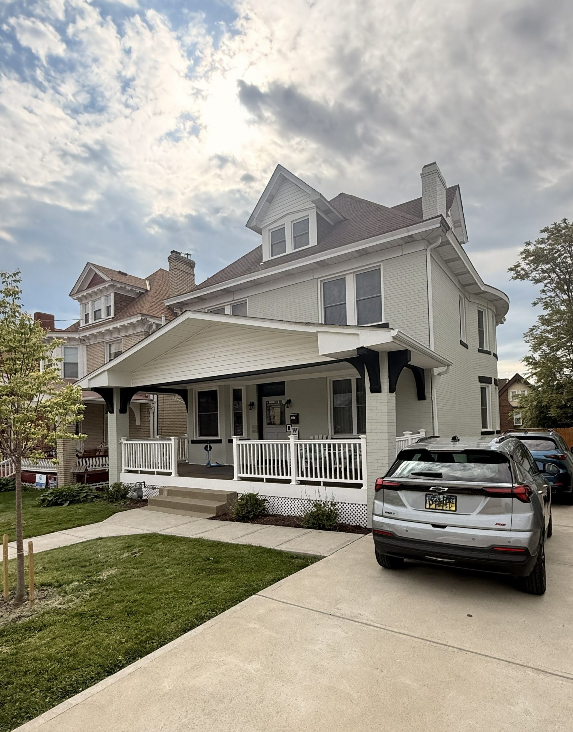 white painted brick home exterior with black accents.