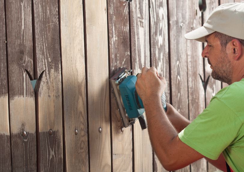 sanding a fence to prep for painting