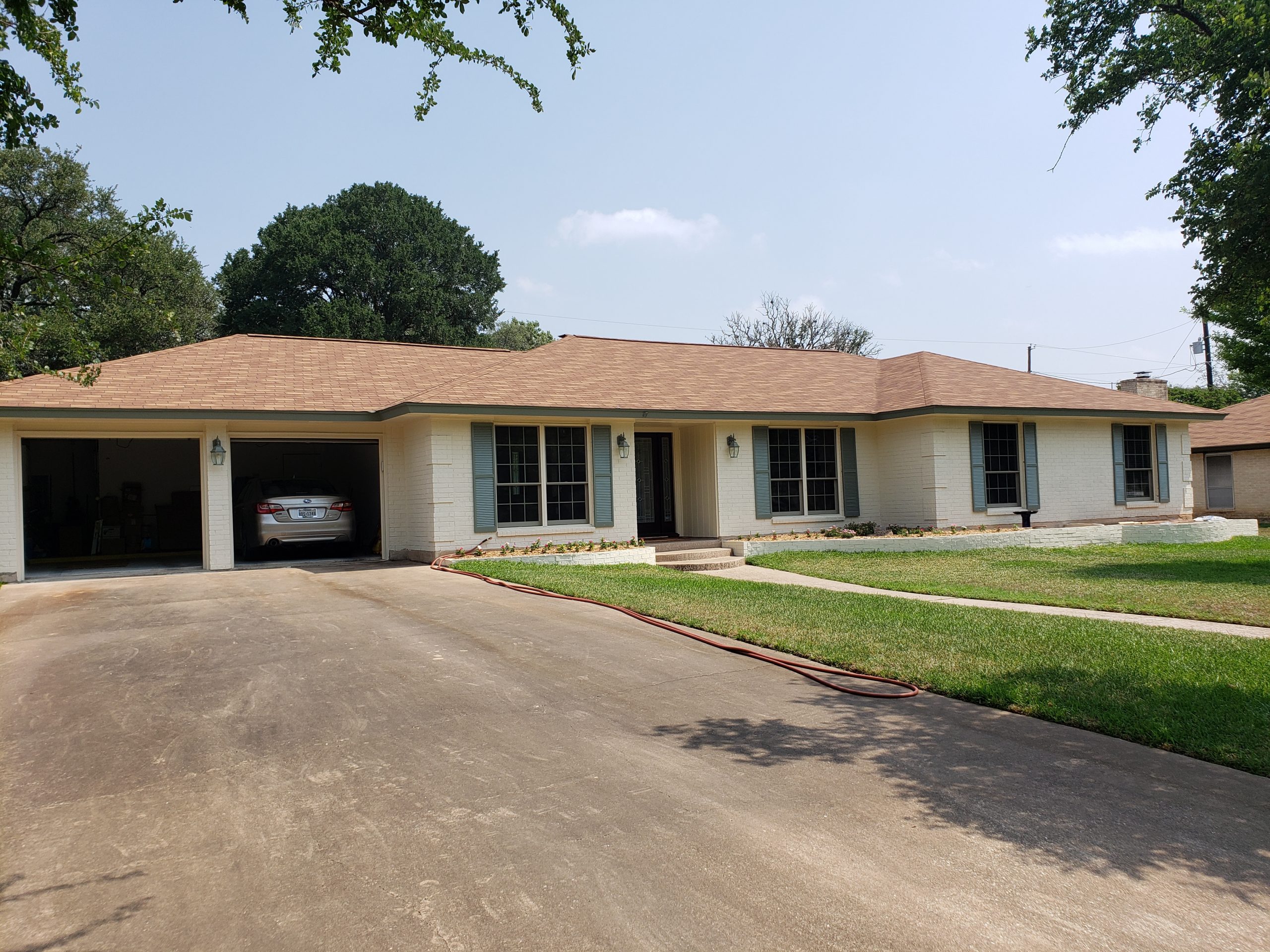 brick house painted with blue shutters