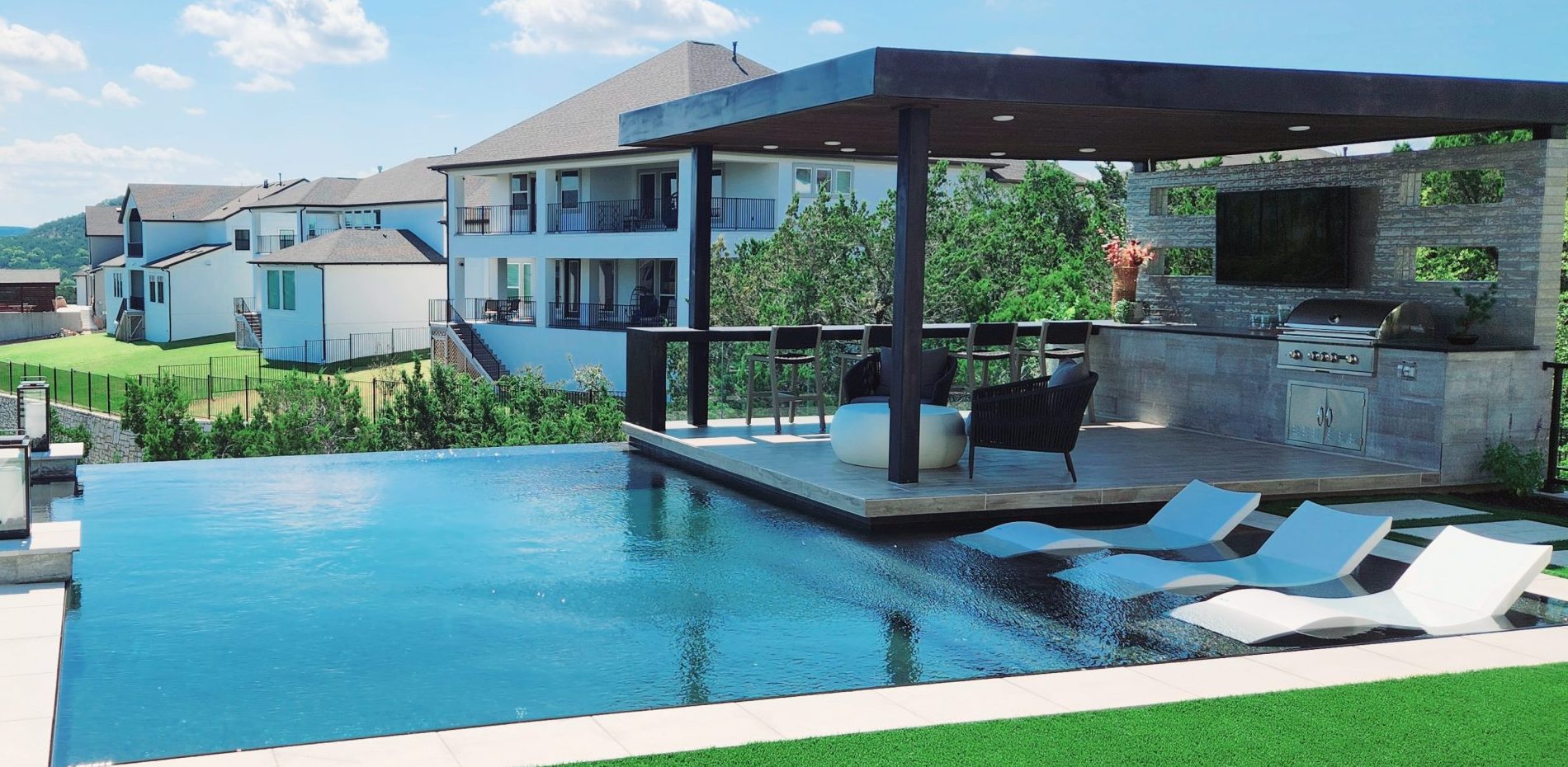 pool next to covered outdoor kitchen area