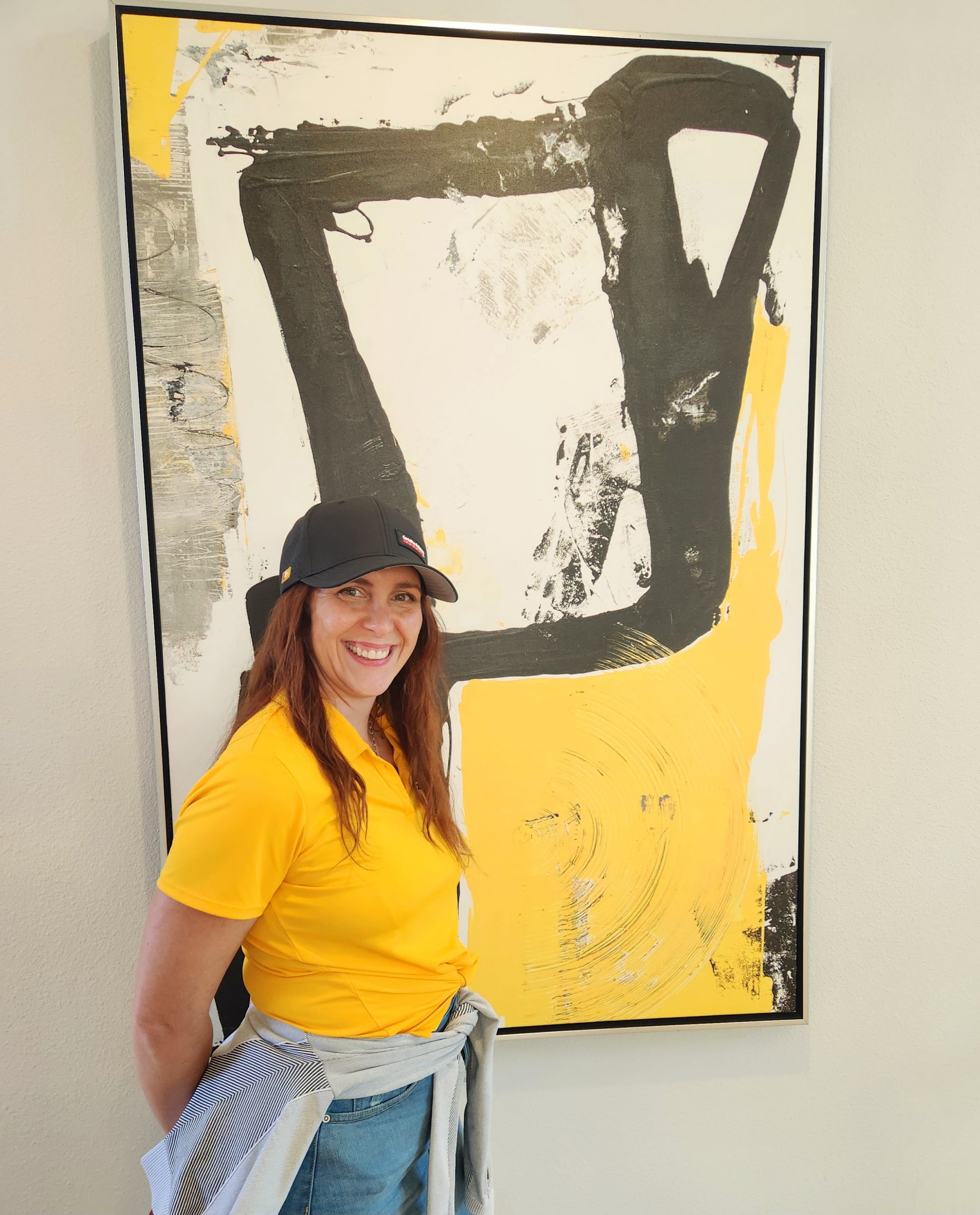 woman smiling next to painting